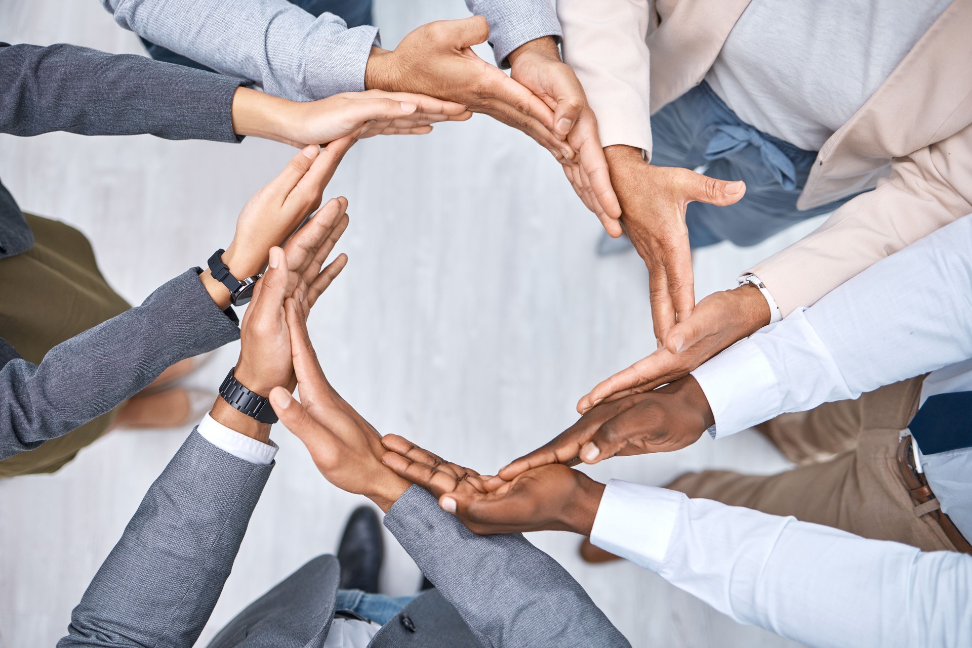 Shot of a group of businesspeople joining their hands to form a circle